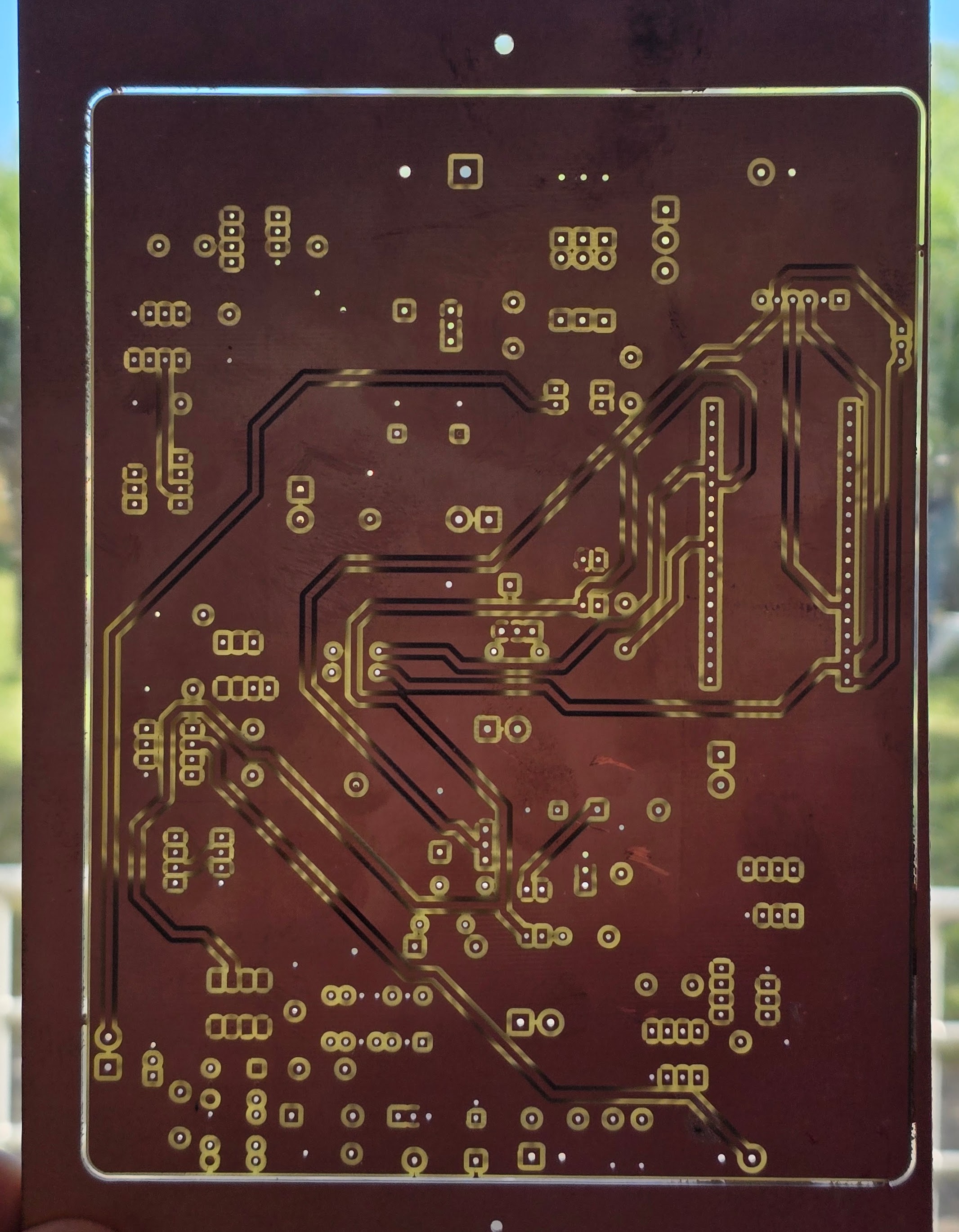 Milled double-sided PCB, front copper, held to the light